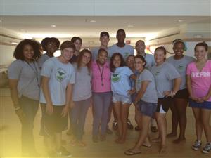 A diverse group of individuals in t-shirts happily pose together for a memorable photo.