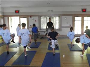 Children engaged in a yoga class, stretching & meditating in a peaceful environment.