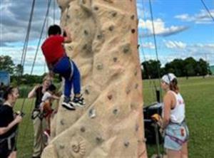 A group of climbers scaling a rock wall, showcasing teamwork & determination outdoors.